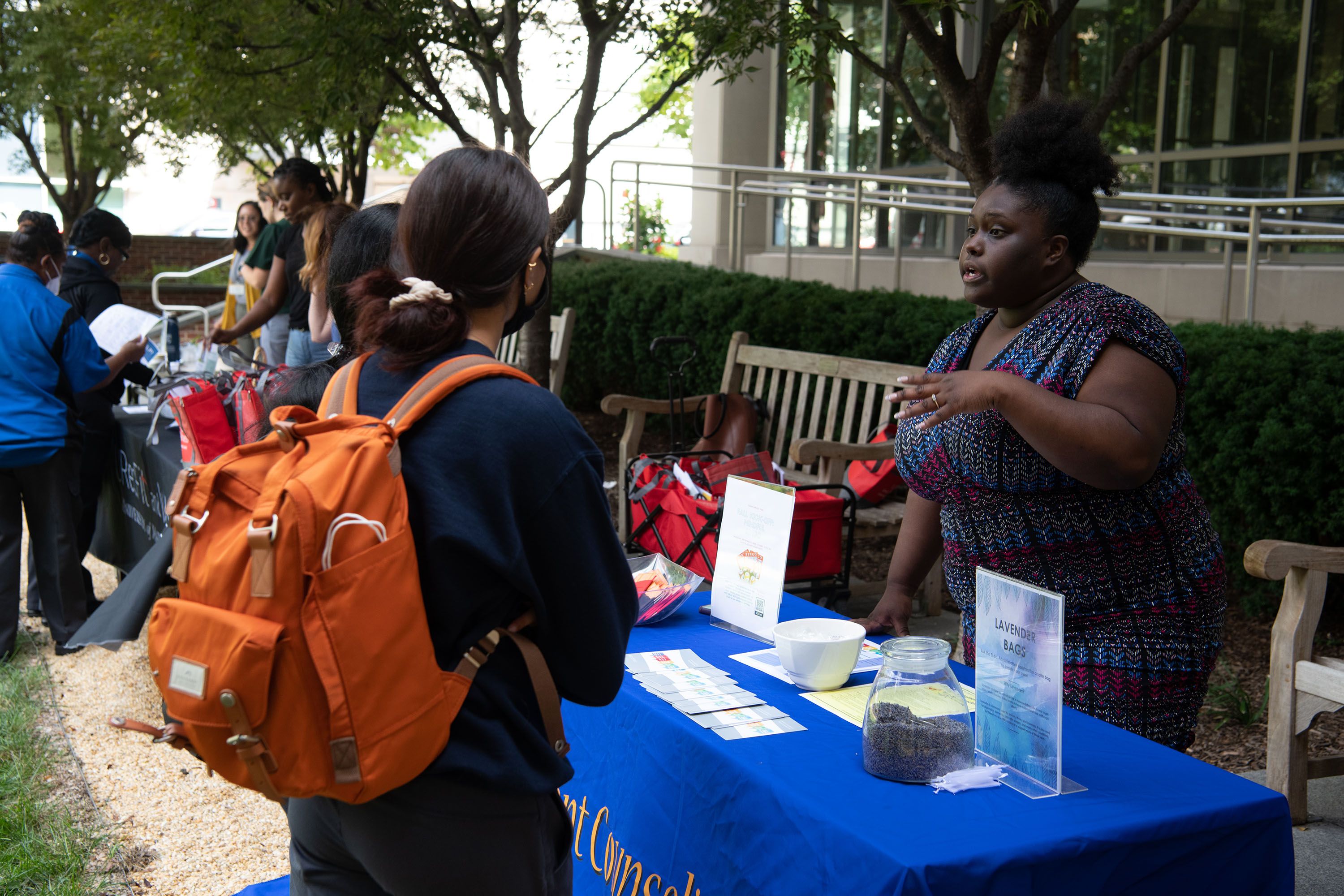 Tierra Major Kearney, senior referral and prevention specialist in the Student Counseling Center speaks to students during an outdoor outreach event
