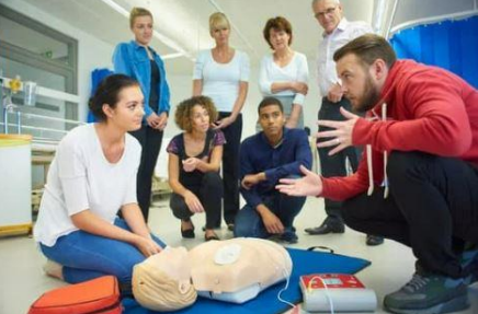 Group of adults bending over dummy learning about CPR