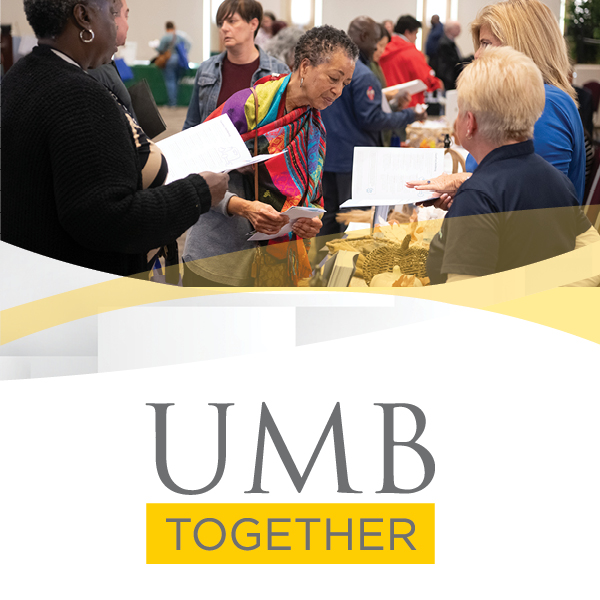 People at table holding information pamphlets about healthcare and benefits at UMB