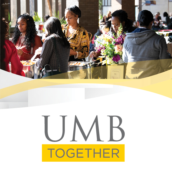 Group of people self-serving food at a UMB event. Beautfiul sunlit photo with standout floral arrangement.