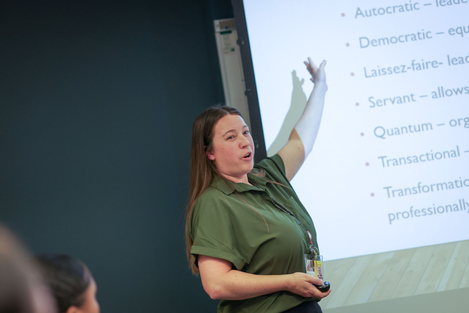 Woman teaching in front of fellow faculty members