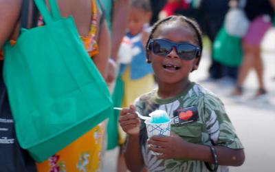 child holding snowball and smiling at Juneteenth Jubilee