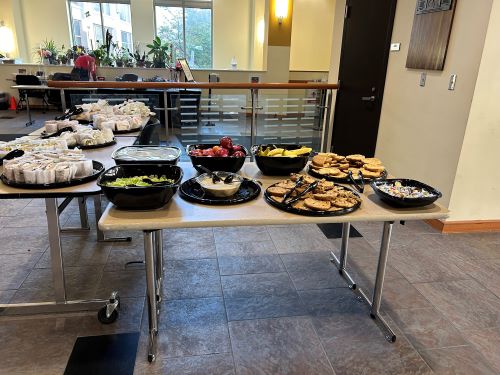 Image of salad, sandwiches, and desserts on a table in the Campus Center that are available for students to pick up after a UMB FREE alert went out. 