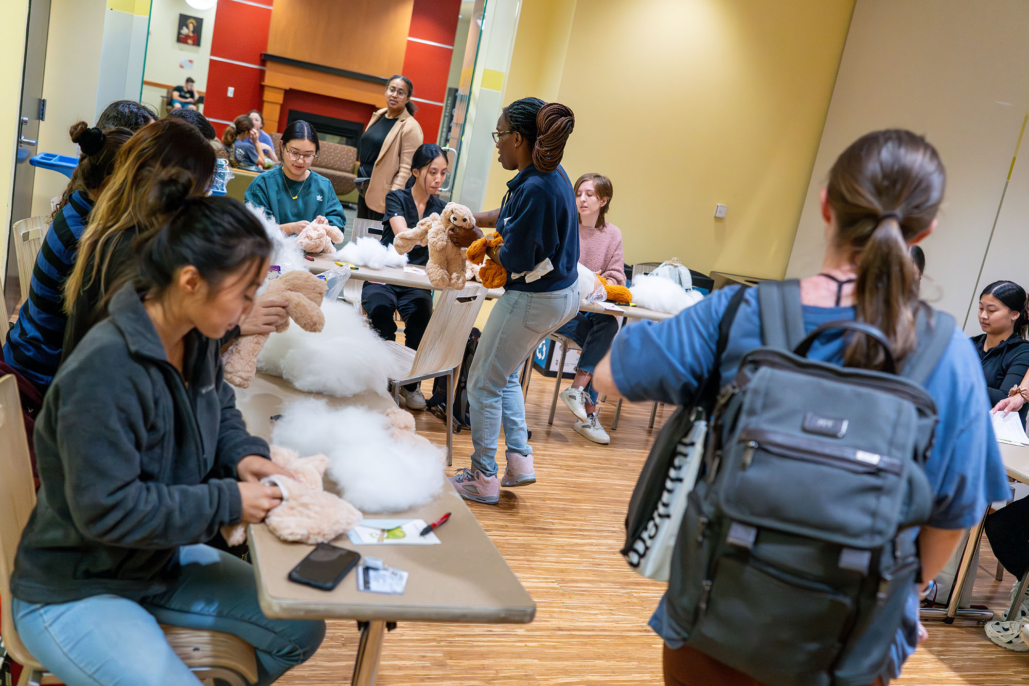 Malika Brown hands an unstuffed bear to a student during the Warm Wishes Workshop.