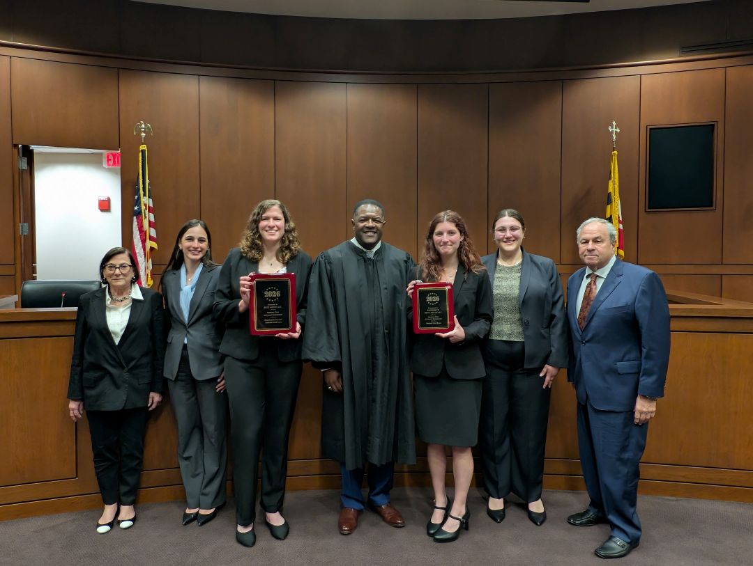 Finalists pose for a picture with the tournament judge and two supporters in the ceremonial courtroom.