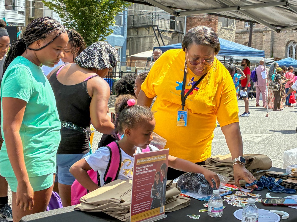 A girl selects stickers and supplies from the Baltimore City Public Schools table at the fifth annual Back-to-School Bash.