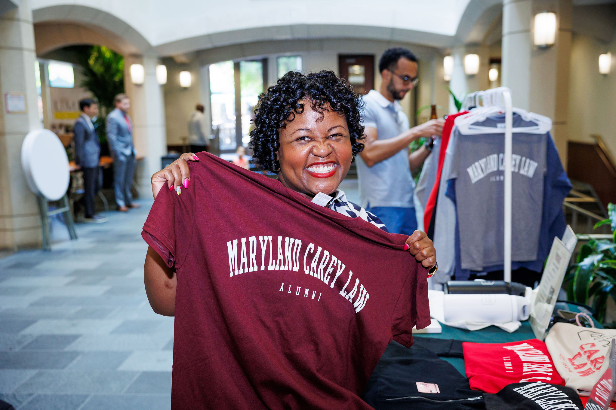 Alicia Wilson holding up a Maryland Carey Law T-shirt