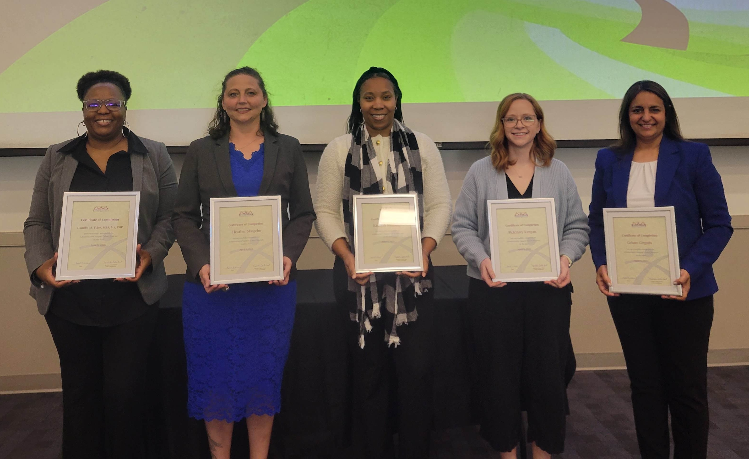 Five of the seven UMB graduates holding their certificates.