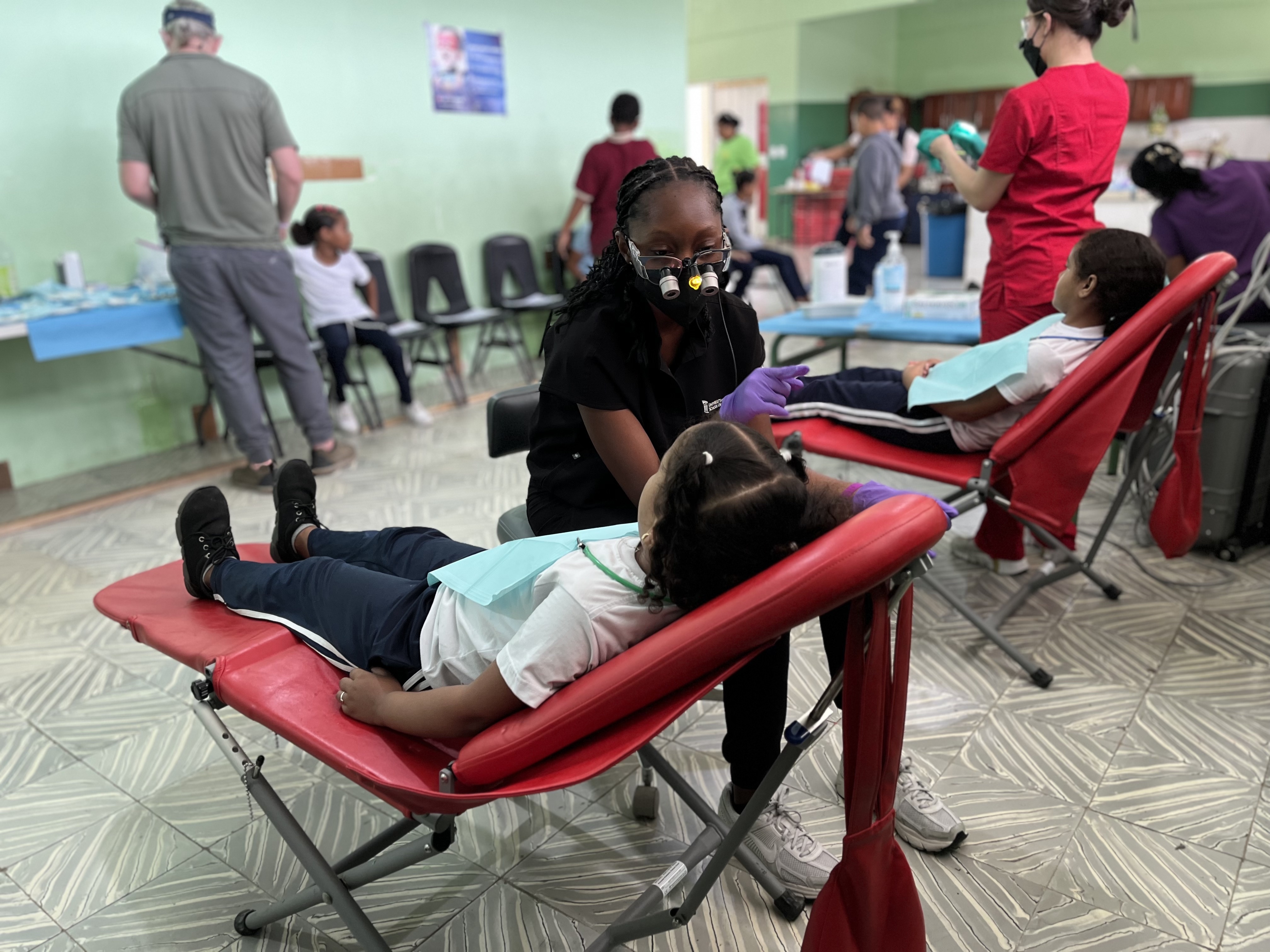 Daphnie Sumah with a young patient in the dental clinic. 