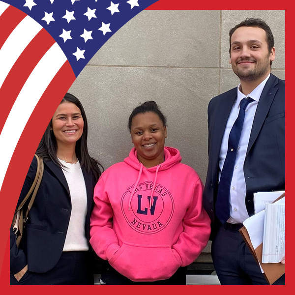 UMB Celebrates America at 250 with U.S. flag and three people outside the Maryland District Court