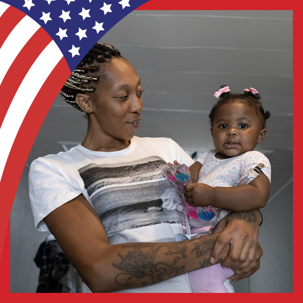 UMB Celebrates America at 250 with U.S. flag and a woman holding a baby