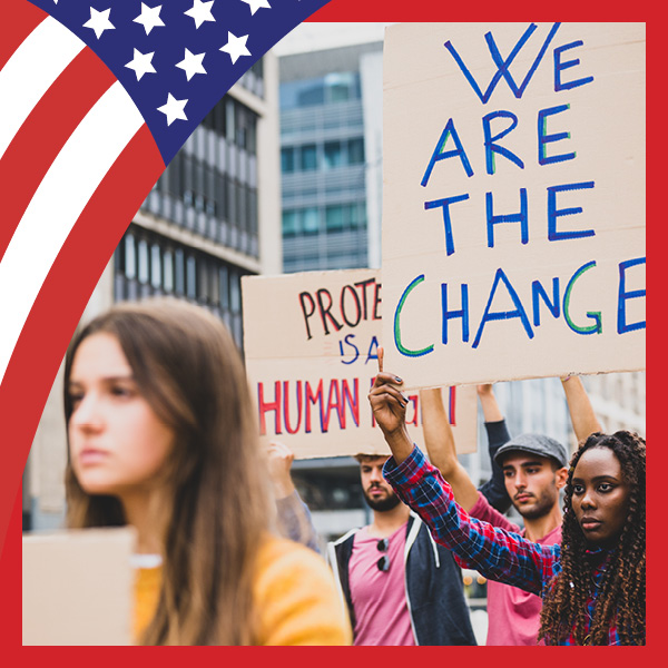 US flag look with woman holding up sign that says WE ARE THE CHANGE