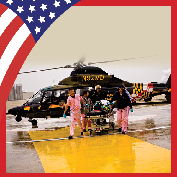UMB Celebrates America at 250 with U.S. flag theme and first responders and other medical personnel escorting a trauma victim