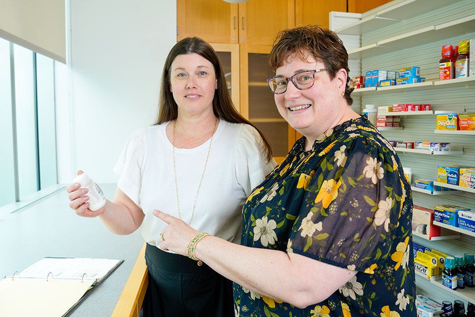 Amy Kruger Howard and Jill Morgan with a bottle of pharmaceuticals