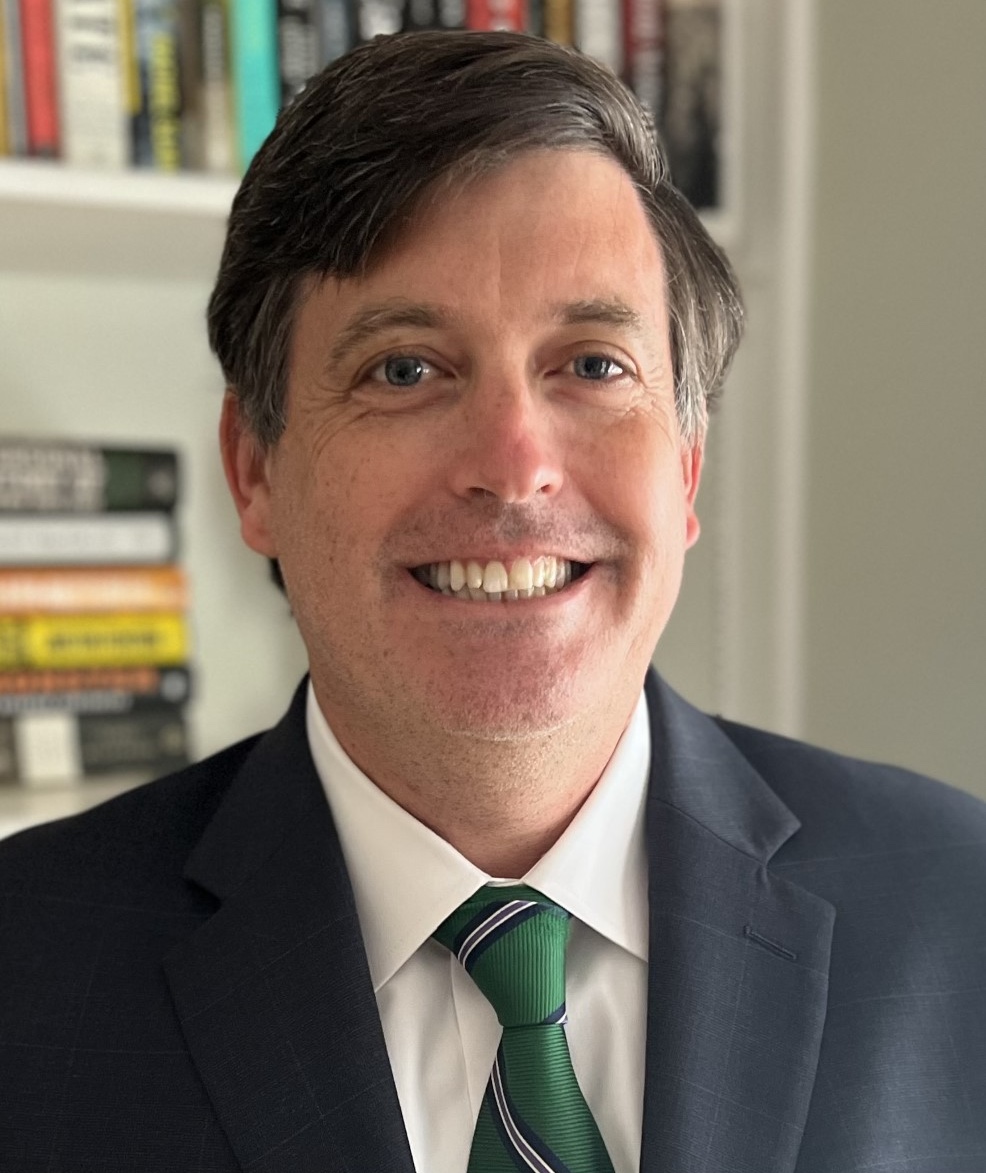 Headshot of Judge Brendan Hurson in a green tie in front of a bookshelf.