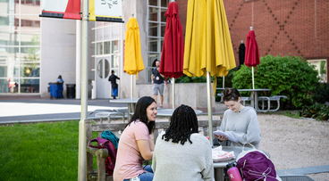 students sitting outside at a table