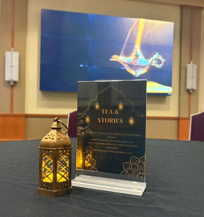 Decorative table display featuring a lit ornamental lantern and a “Tea & Stories” sign.