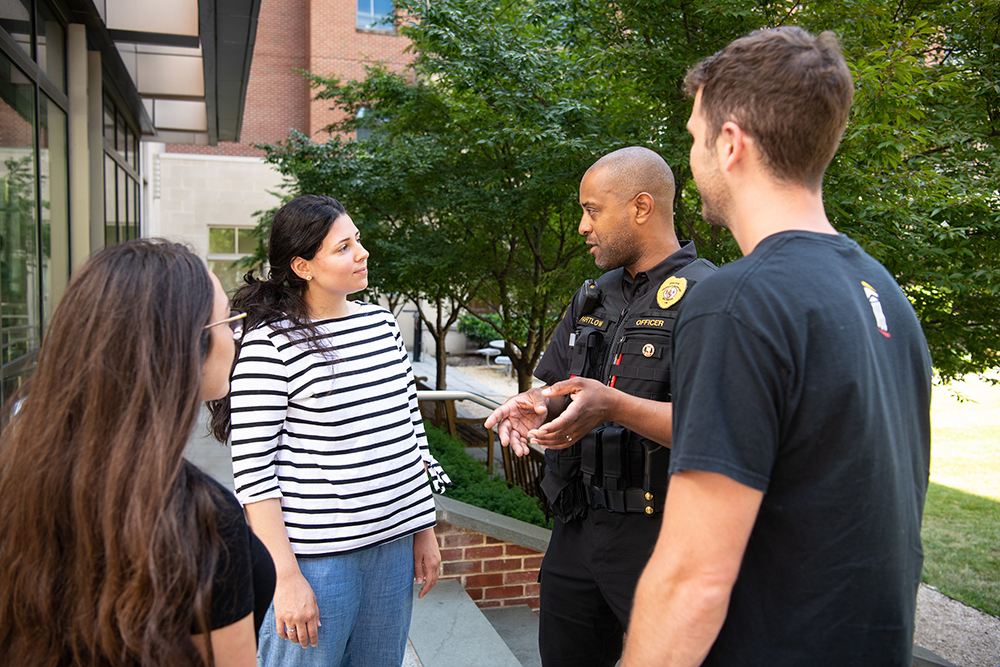 Pfc. Yale Partlow, a member of COAST, talks with three students