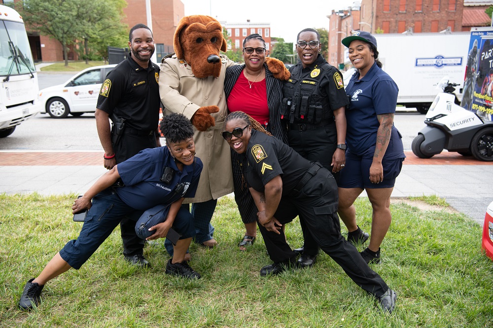 UMB Police, Baltimore Police, and UMB Senior Vice President Dawn Rhodes pose with McGruff the Crime Dog