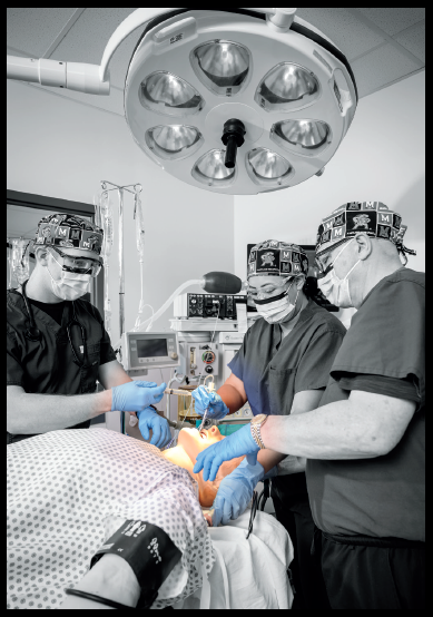 Pellegrini (far right) instructs students Patrick Booth, BSN, RN, (left) and Janet Su Olivares, BSN, RN, (center) through an endotracheal intubation using a high-fidelity manikin