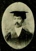 Black and white portrait of a Japanese man in graduate cap and gown