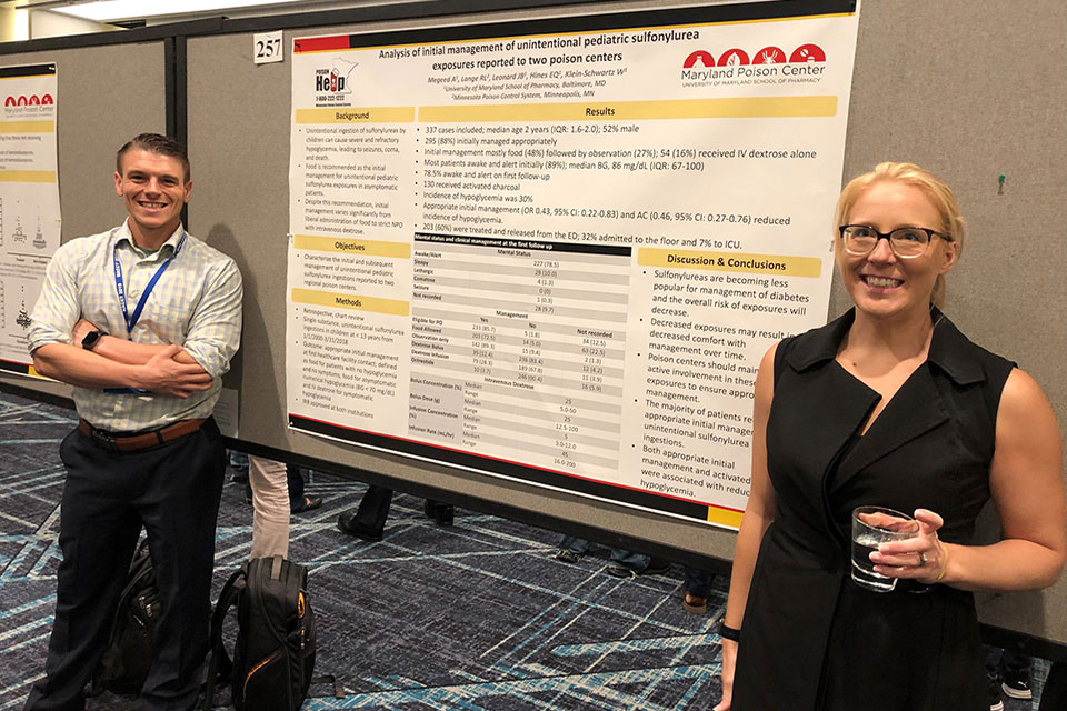 Drs. James Leonard and Elizabeth Hines pose for photo with a poster they presented during NACCT.