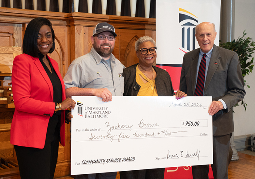 Zachary Brown, second from left, stands with Malika Monger, Dawn Rhodes, and Bruce Jarrell after winning the UMB Community Service Award.