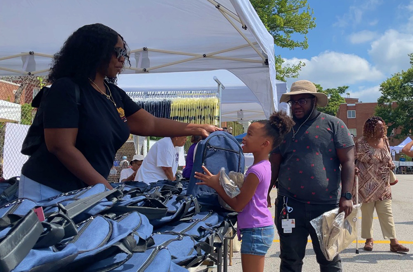 A girl gets a backpack during the Back to School Bash
