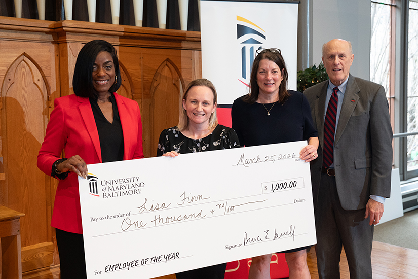 Holding her check for winning Employee of the Year, Lisa Finn stands with Malika Monger, Agnes Ann Feemster, and Bruce Jarrell.