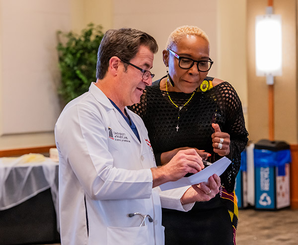 Dean Mark Gladwin, left, talks with Cathy Mwangi.
