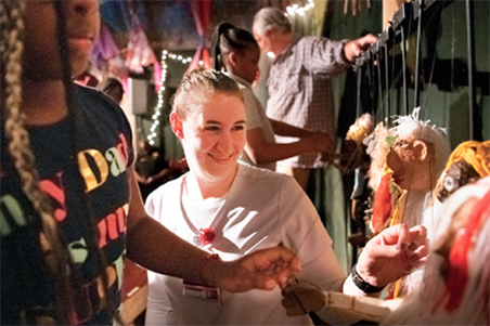 Britta Kilbourn, BA, an UMSON CNL student, helps prepare for a performance of Cinderella In our City at the Black Cherry Puppet Theater.