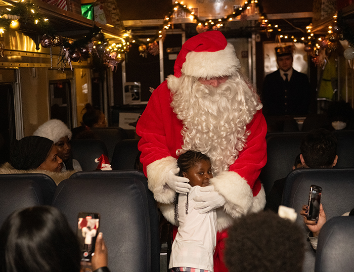 A child hugs Santa Claus on the Polar Express