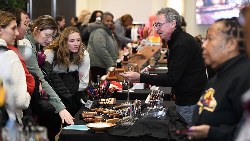 Shoppers check out the wares at one of the vendor tables