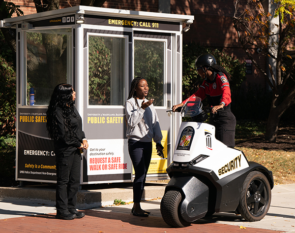 UMB security officer talks to two people